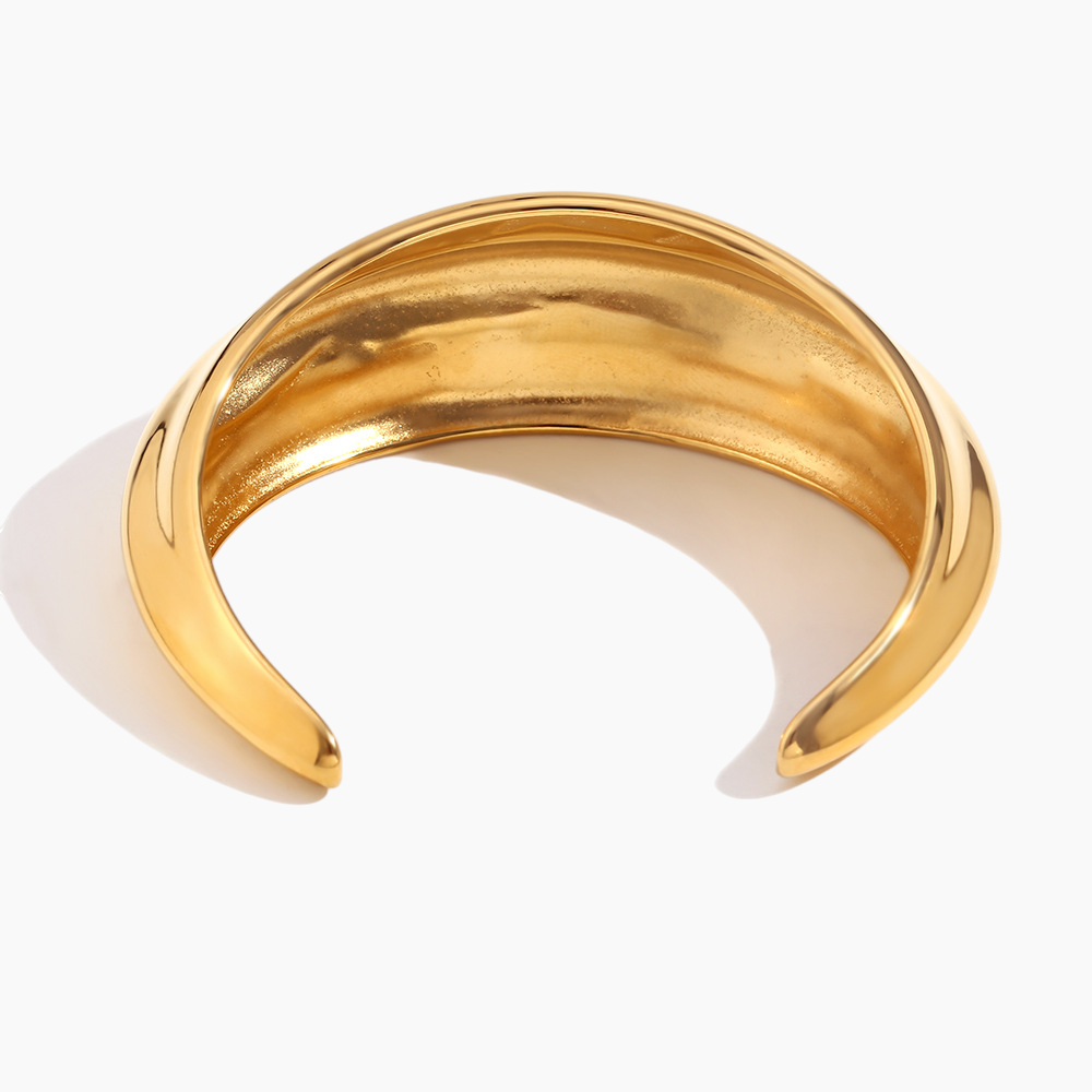 Dome cuff catching soft sunlight highlighting polished finish on wrist