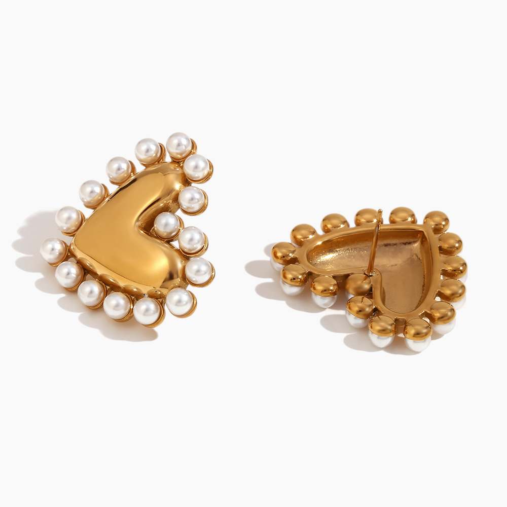 Gold earrings with pearl accents on a white background
