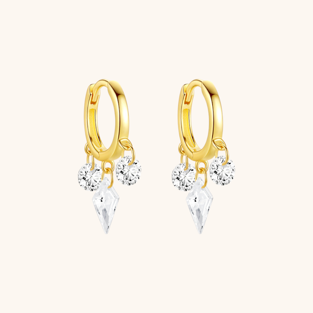 Close-up side view of gold hoop earrings with three cubic zirconia charms