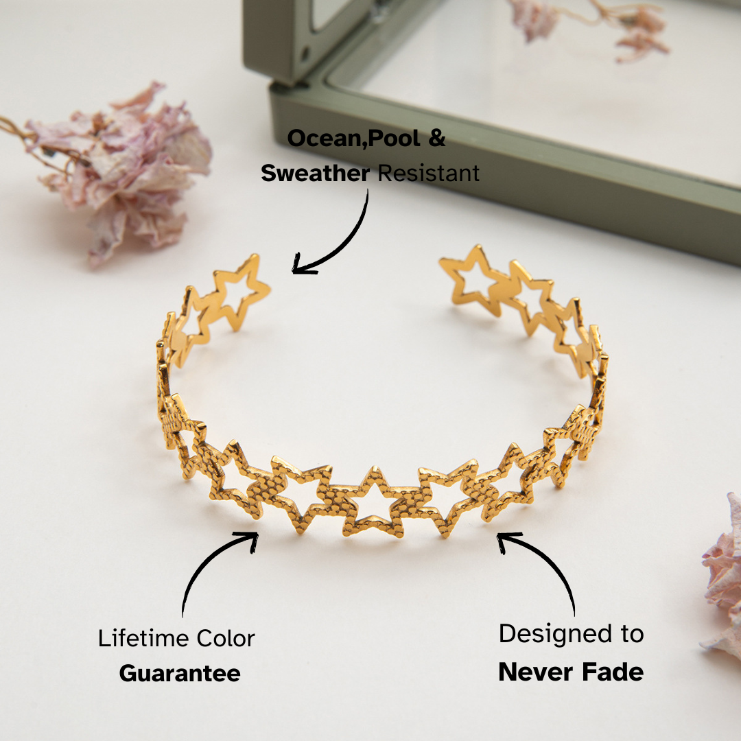 Open gold star cuff placed on green gift box