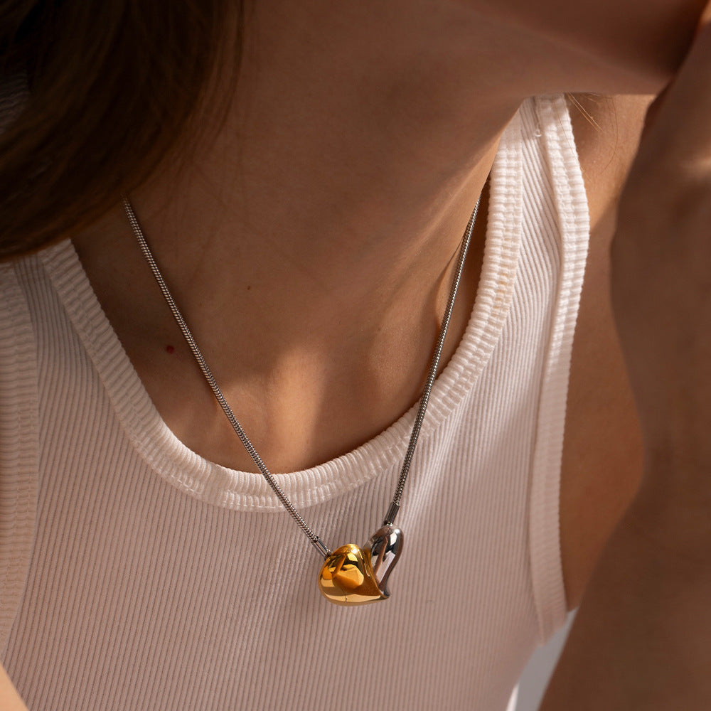 Model wearing silver and gold mixed metal heart pendant necklace with snake chain