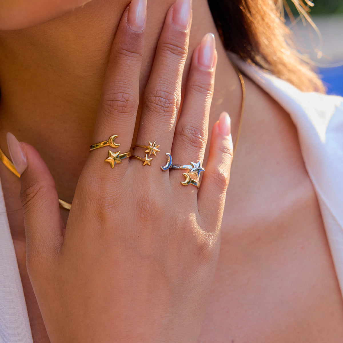 Stackable star and moon rings on female hand outdoors