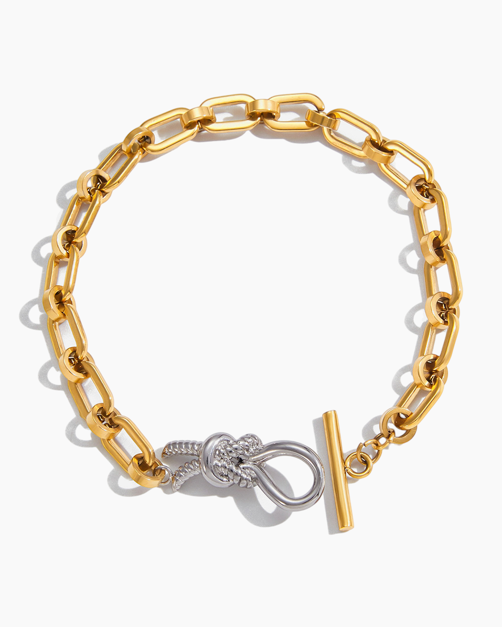 Gold chain bracelet with a knot design and clasp on a white background