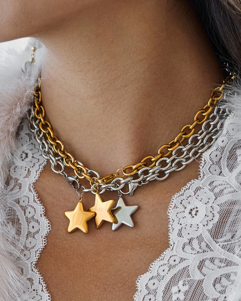 Necklace with star charms on a person wearing a white lace garment