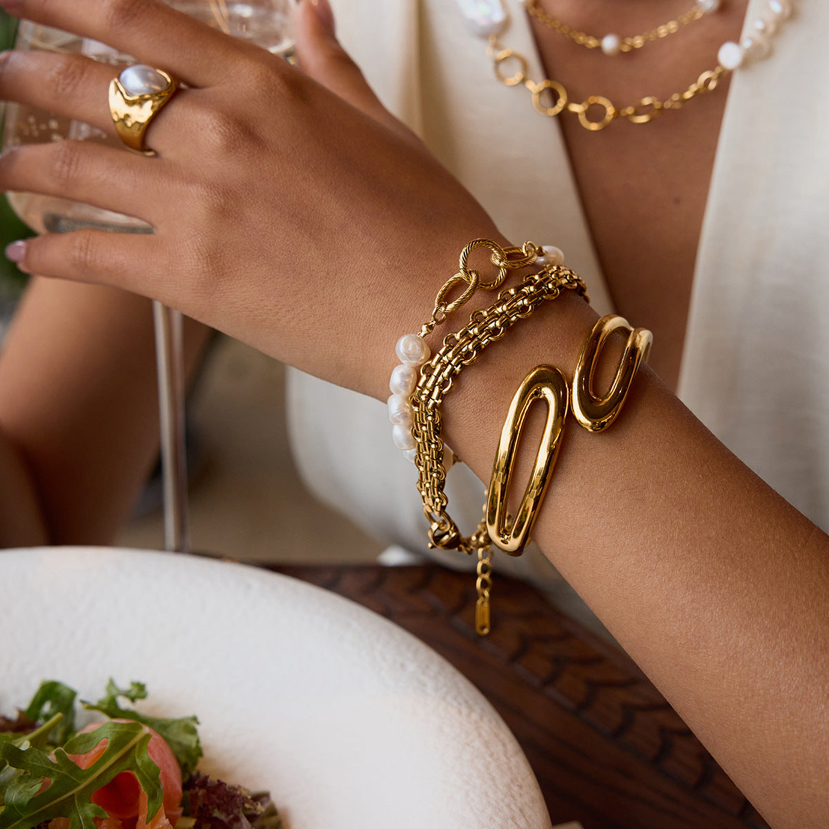 Mixed chain and pearl bracelet styled during brunch with wine and salad