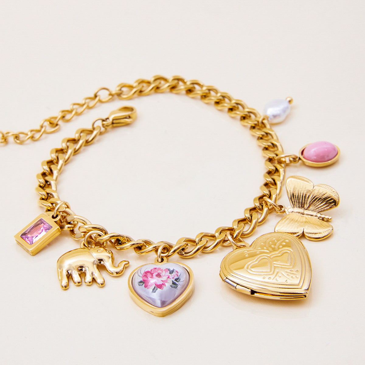 Vintage-style locket charm bracelet with elephant and pearl accents