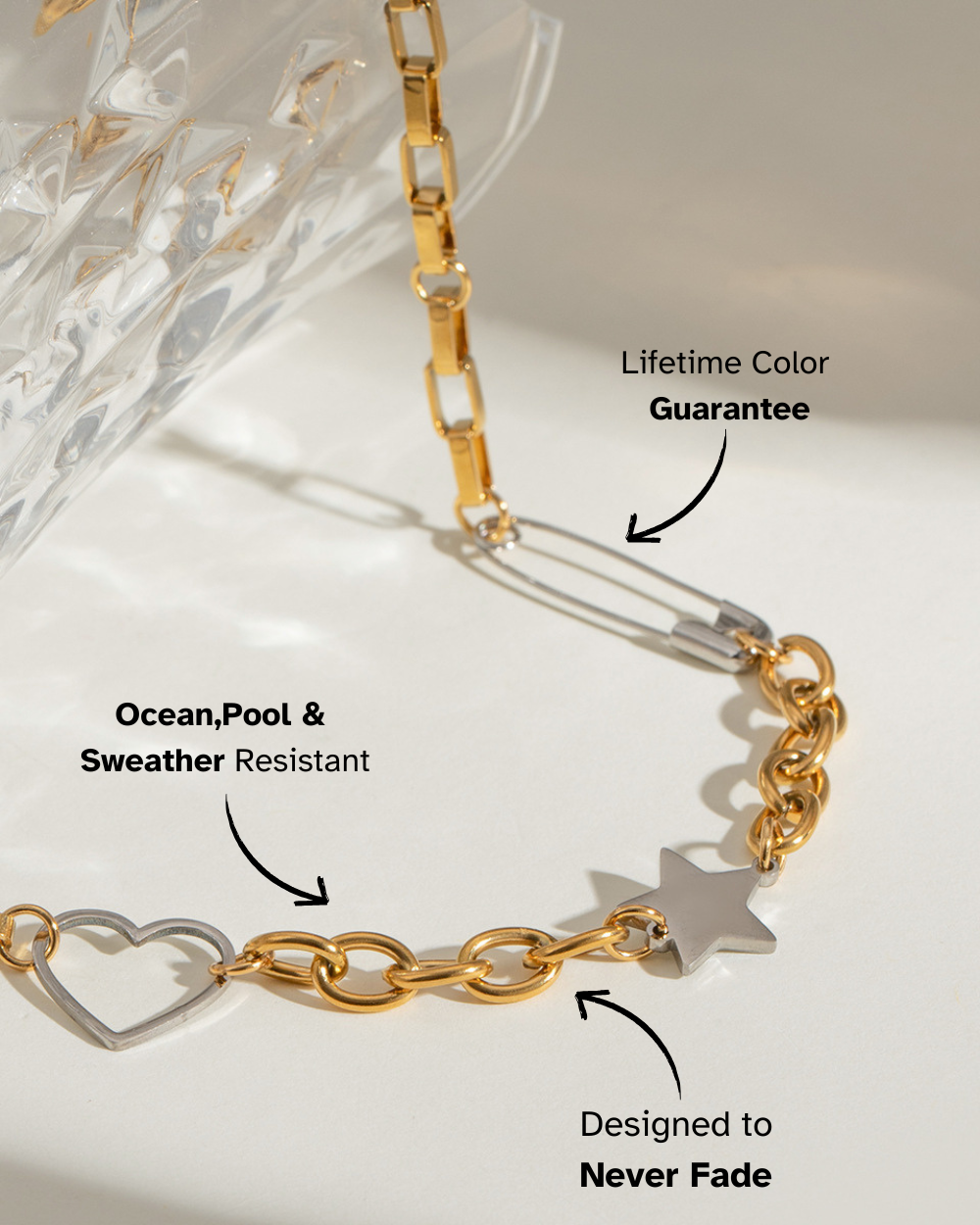 Gold chain bracelet with heart and star charms on a white background