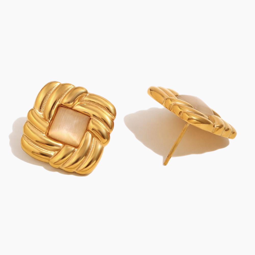 Gold earrings with a beige center on a white background