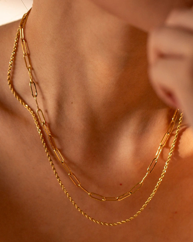 Close-up of a person wearing a gold chain necklace.
