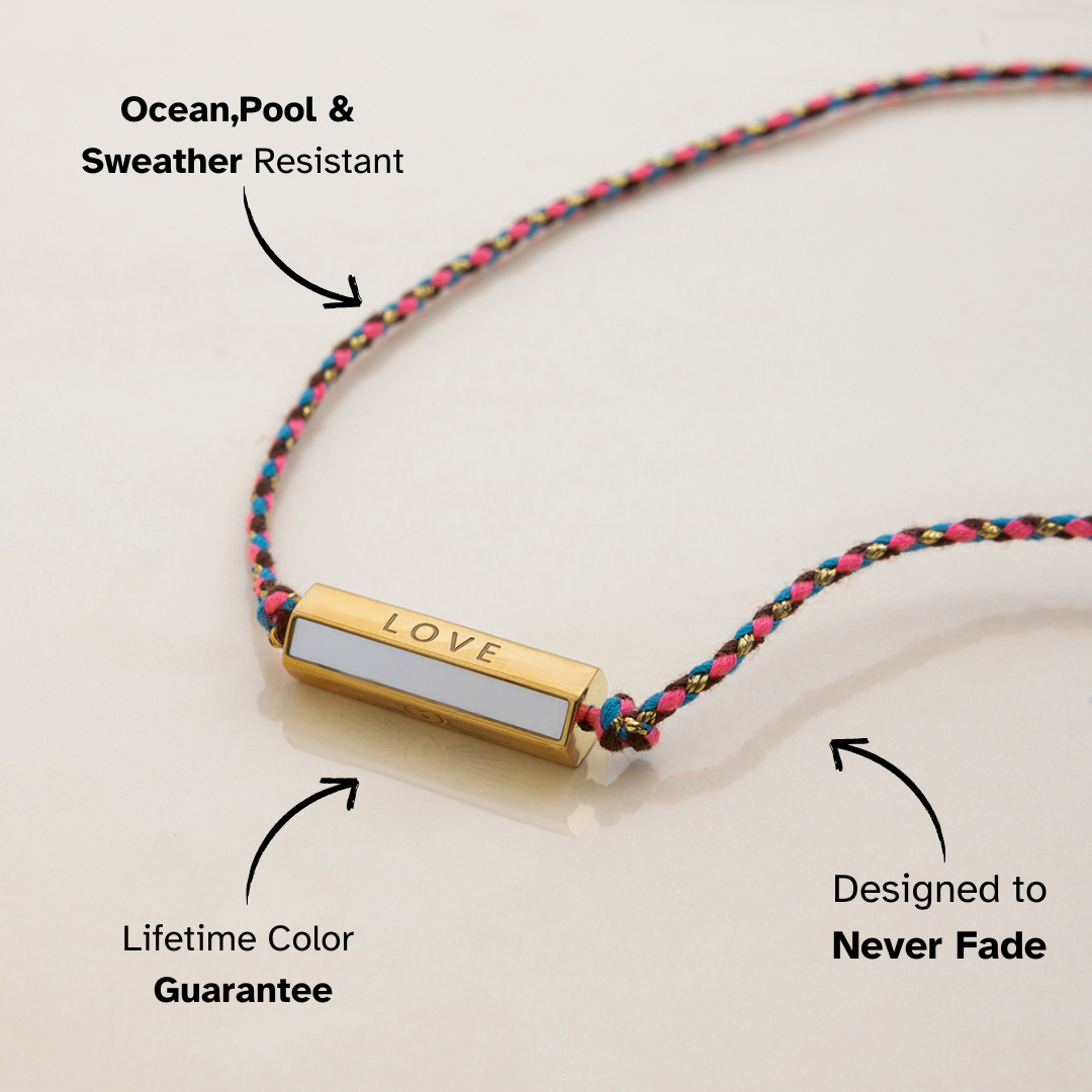 Close-up of gold LOVE pendant necklace with colorful braided cord