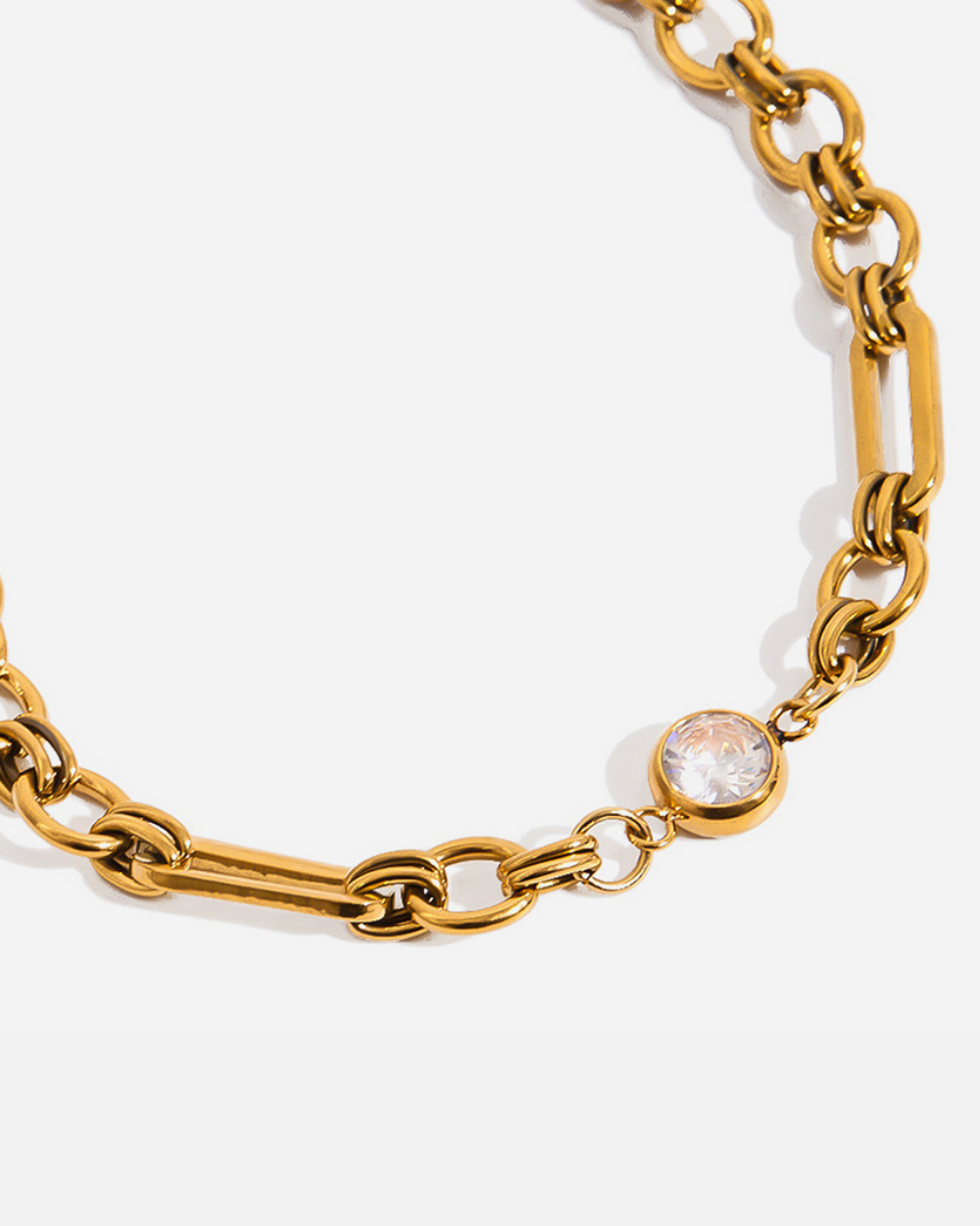 Gold chain bracelet with a gemstone on a white background