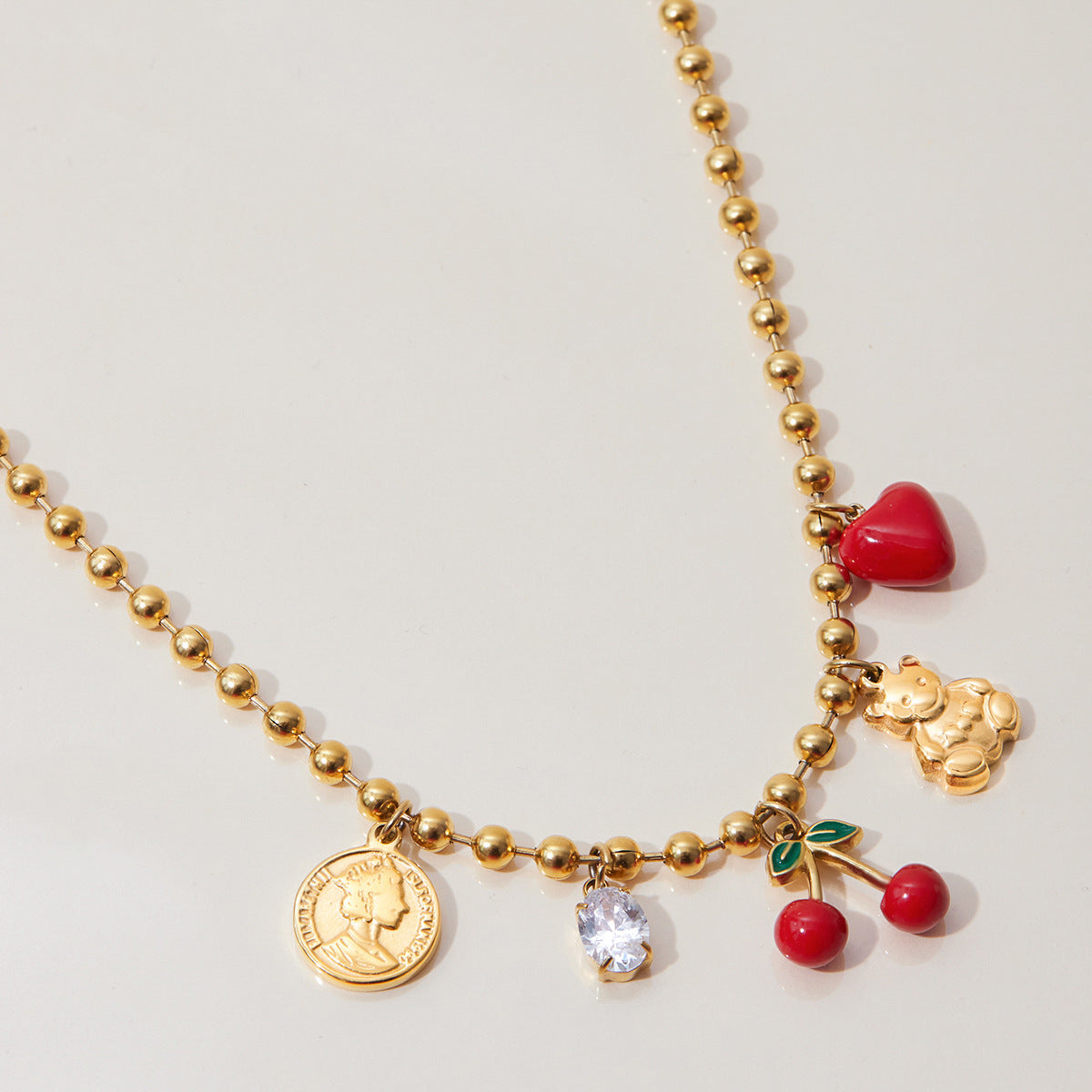 Summer charm necklace flat lay with iced tea and cherries