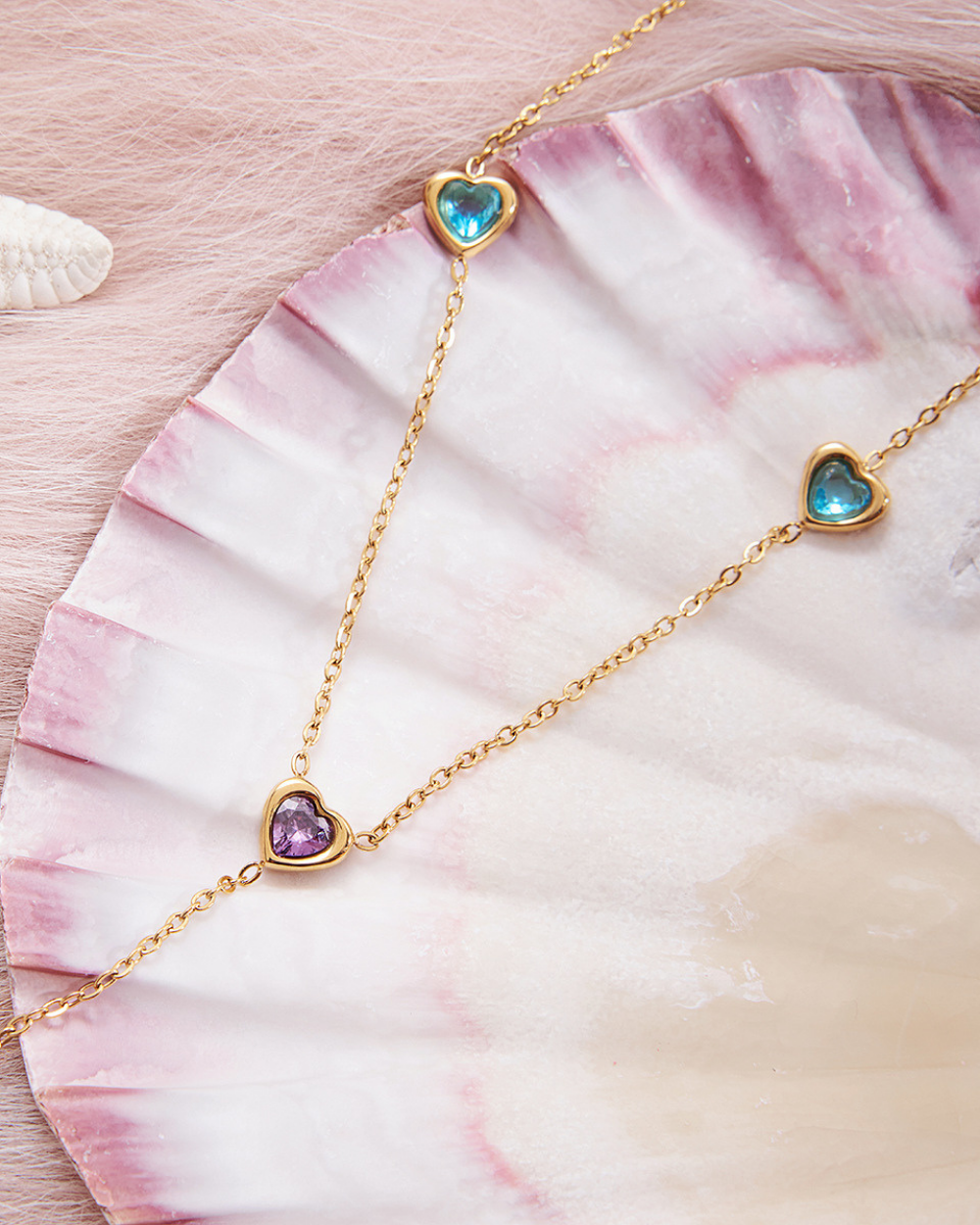 Necklace with heart-shaped gemstones on a seashell
