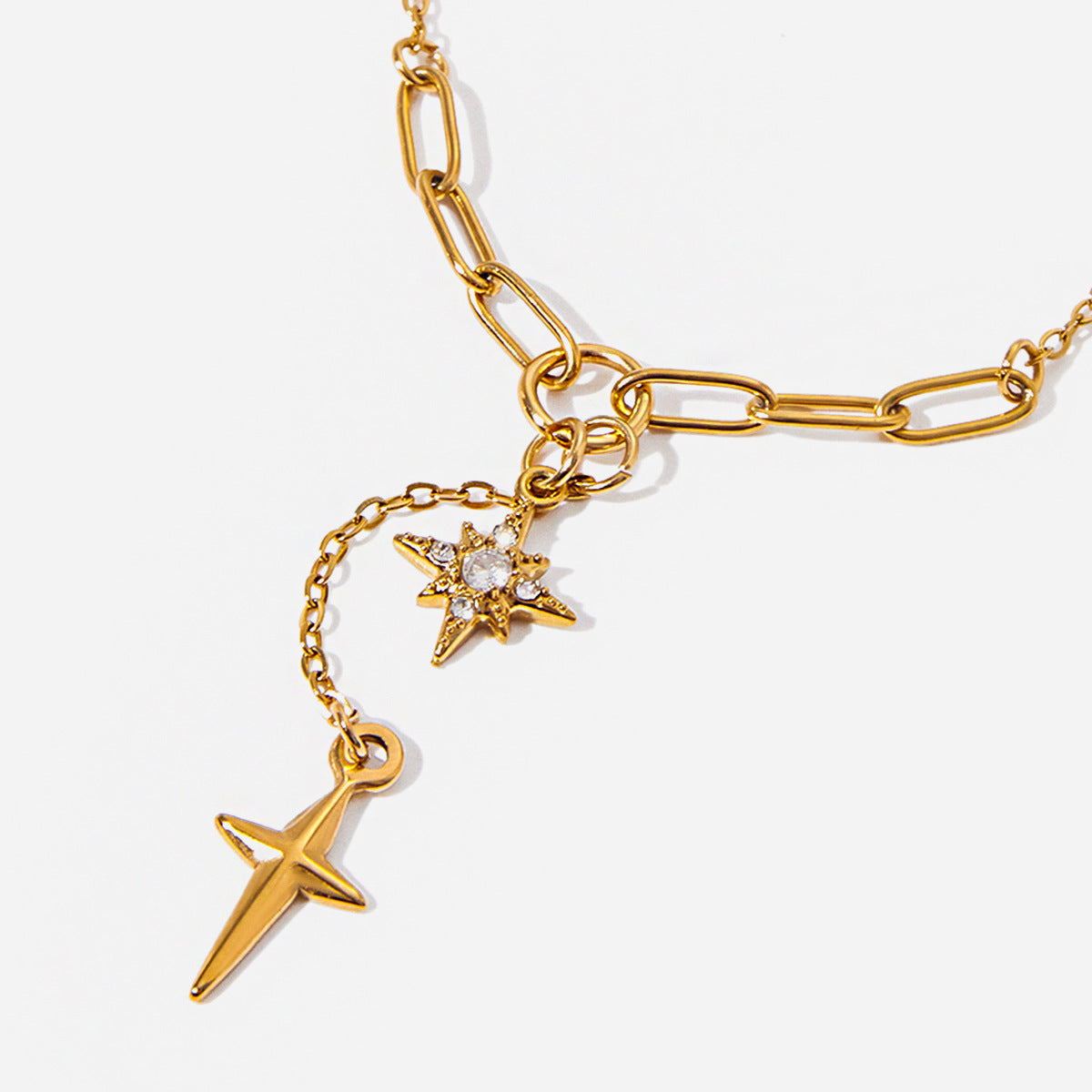 Gold chain bracelet with star-shaped charms on a light gray background