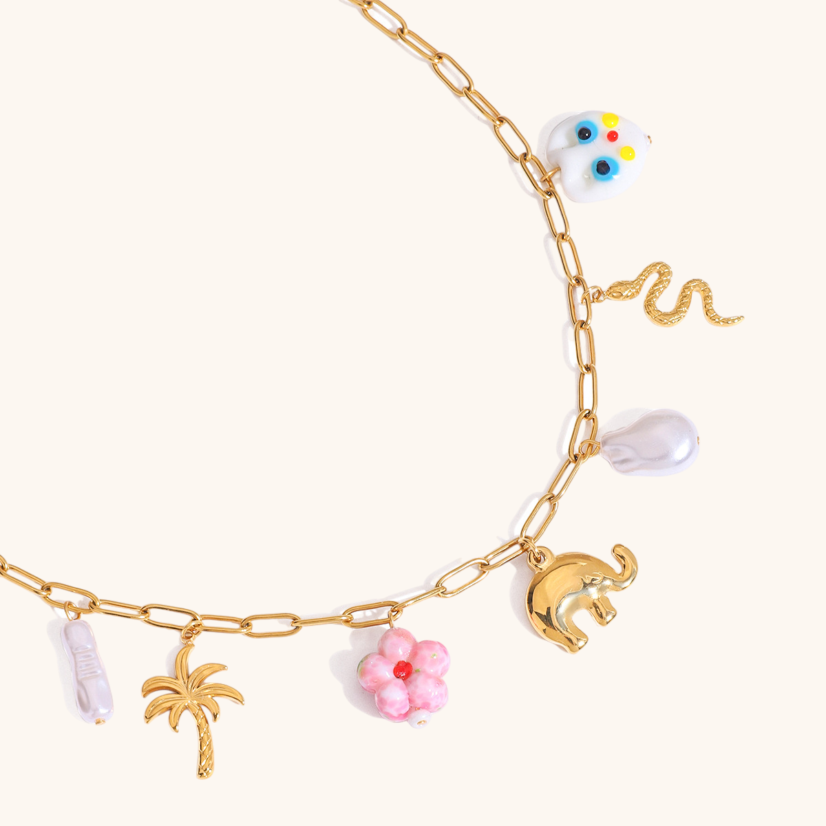 Boho necklace with enamel charms and baroque pearl styled on a yellow floral dress
