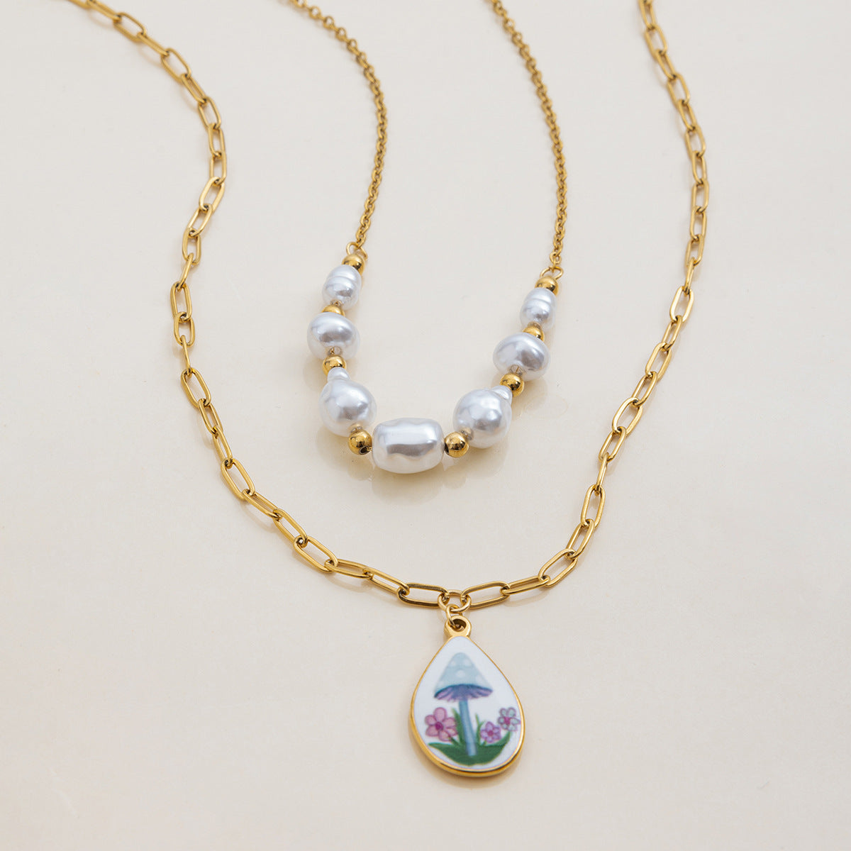 Artistic back view of mushroom charm with gold teardrop backplate, paired with pearls