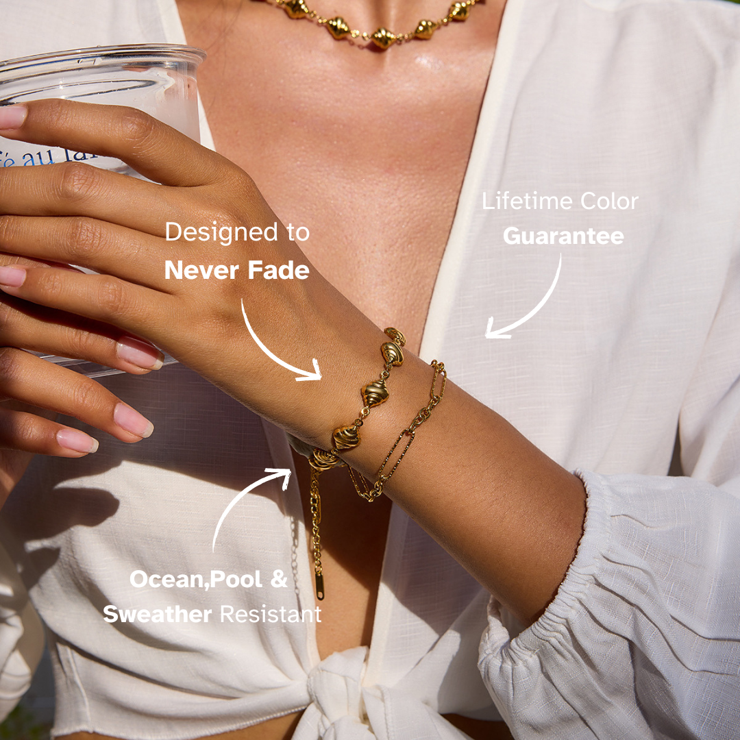 Model wearing minimalist gold chain bracelet alongside a watch.