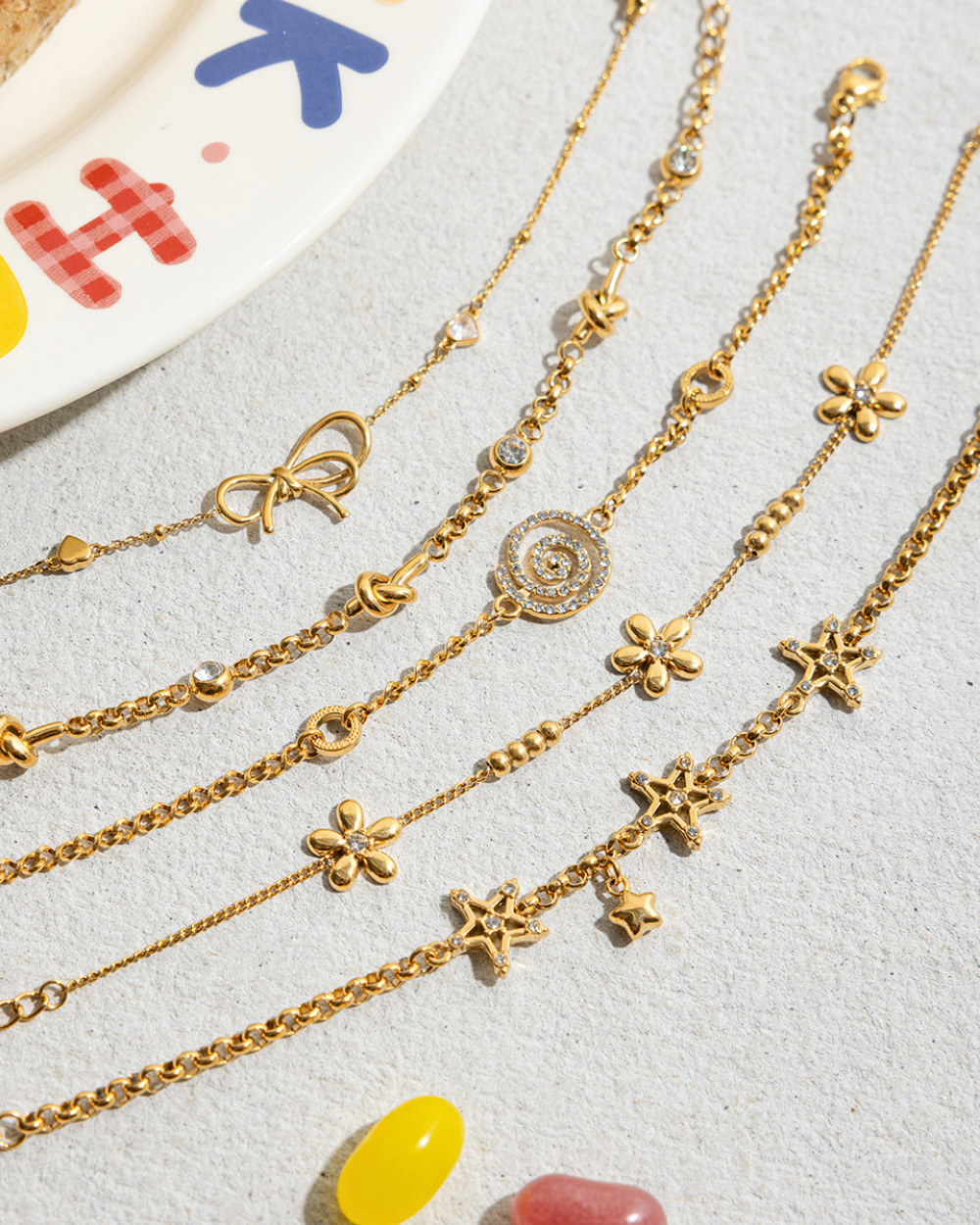 Gold necklaces with various charms on a light gray surface