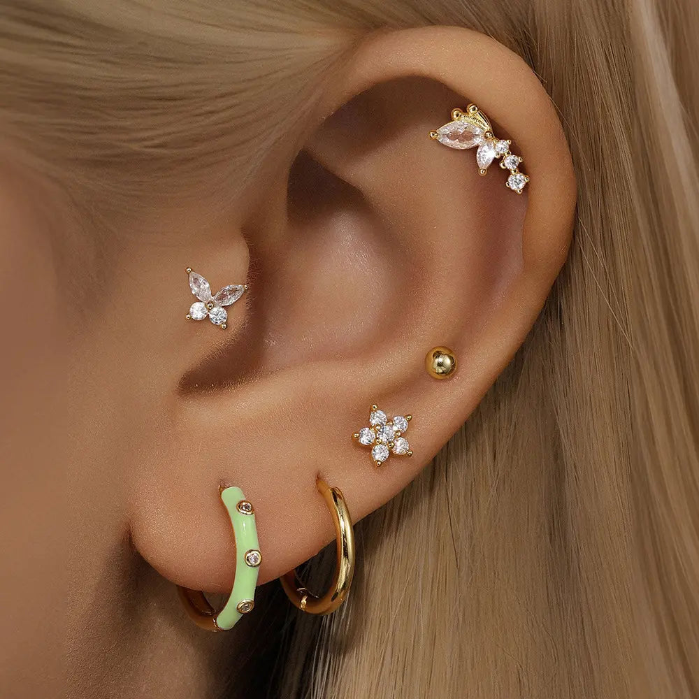 Model wearing 14K gold butterfly-shaped zirconia stud earrings, featuring clear zirconia stones in an elegant butterfly shape. The earrings are styled with other fine jewelry pieces for a chic and layered look.