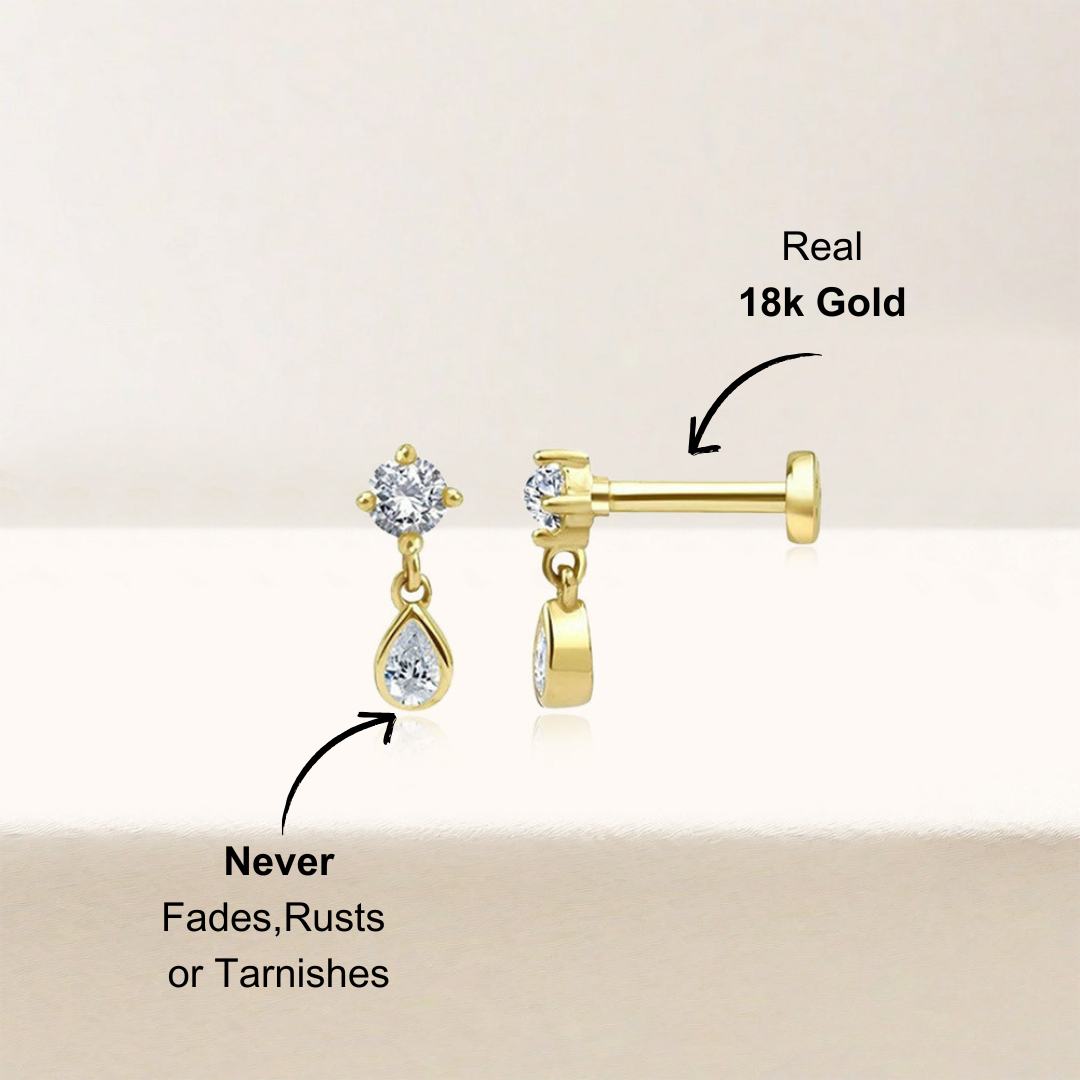 14k gold teardrop-shaped zirconia earrings on a soft, neutral background highlighting the sparkling stones
