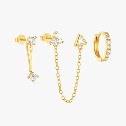 A set of three mismatched gold earrings, including a triangle charm with a chain, a stud with a curved bar, and a small hoop with crystals.