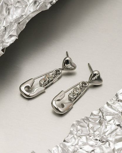 Silver earrings with gemstones on a reflective surface