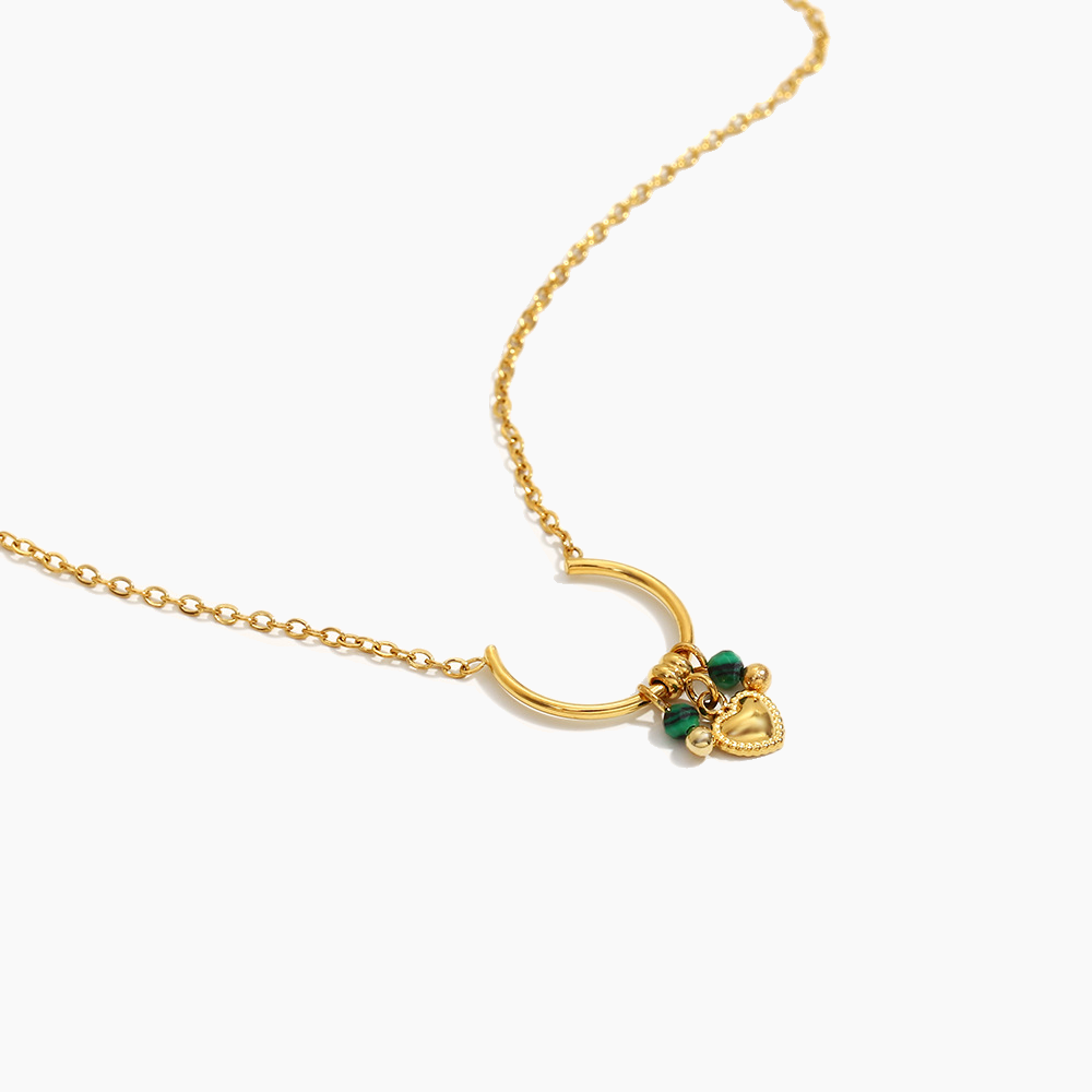 Gold necklace with a heart-shaped pendant on a white background