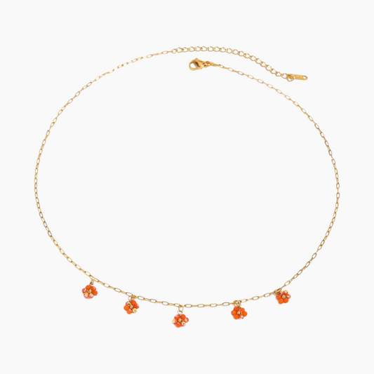 Gold necklace with orange flower pendants on a white background