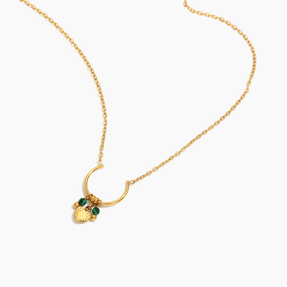 Gold necklace with a heart-shaped pendant on a white background