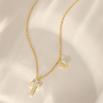 Flat lay of a gold cross necklace featuring a delicate floral charm, made with 925 sterling silver and sparkling cubic zirconia.