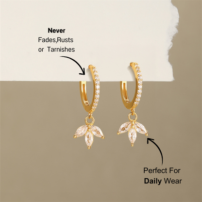 925 sterling silver drop earrings with a leaf design and cubic zirconia stones, elegantly displayed with a soft background.