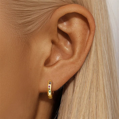 Model wearing 925 sterling silver colorful zirconia hoop earrings with multicolored stones in green, red, and purple