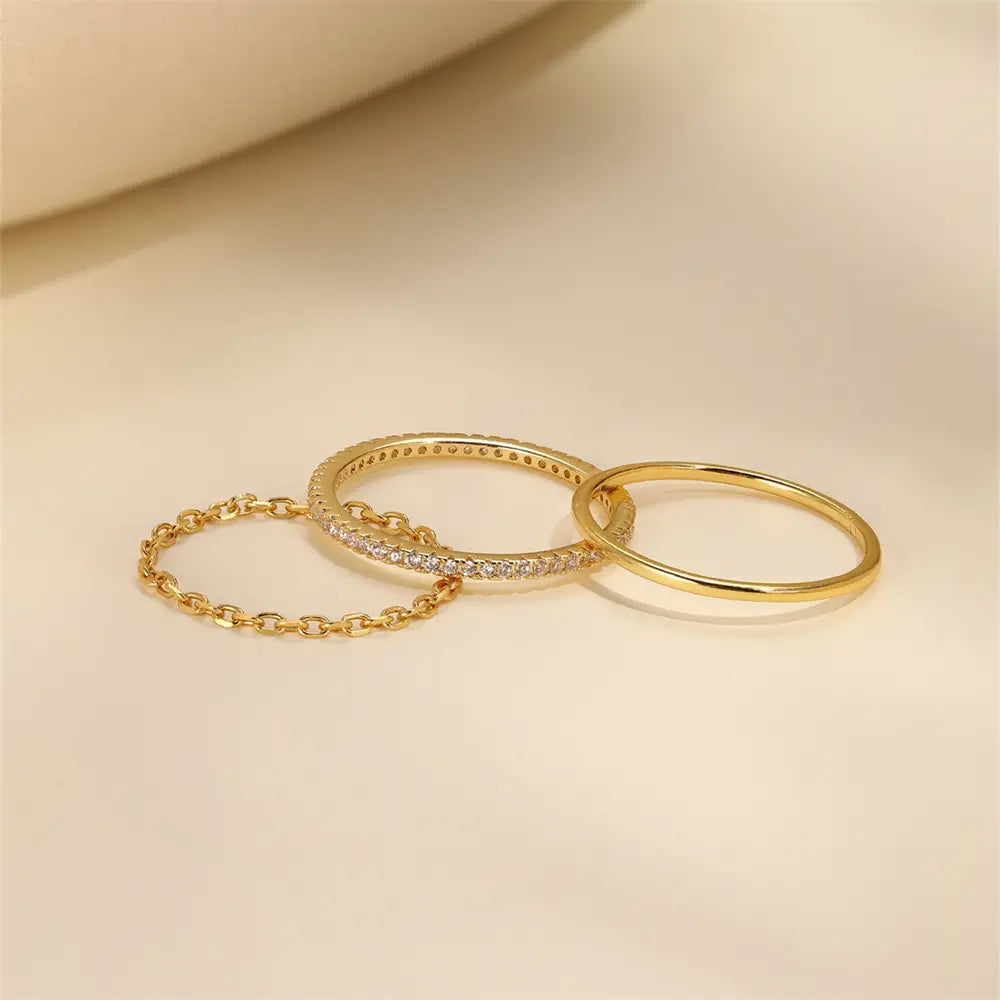 Three-piece ring set with zirconia stones, featuring a chain link design, in 925 sterling silver with gold plating, on a neutral background