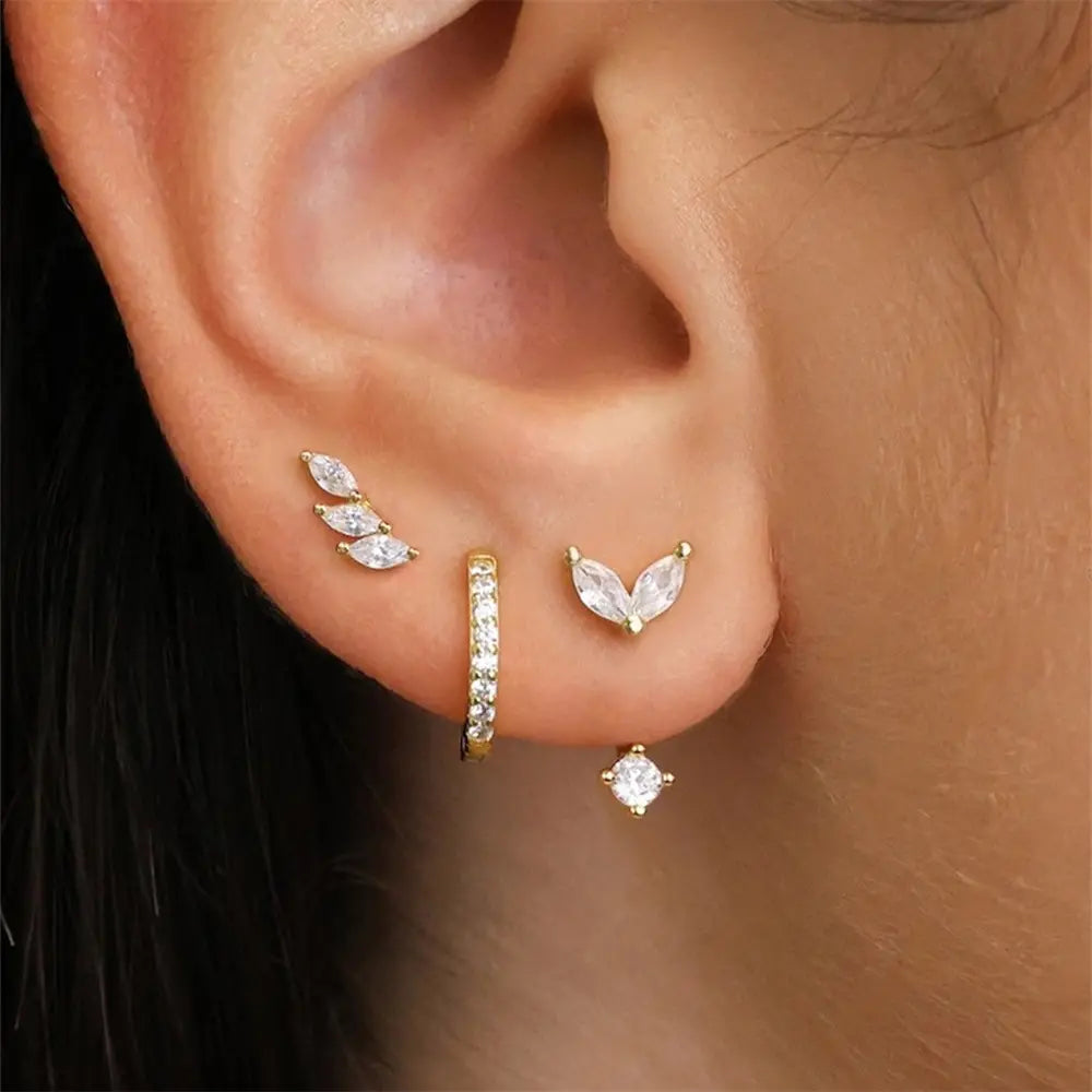 Model wearing a stylish three-piece leaf design earring set with zirconia stones, including studs, chain earrings, and hoop.