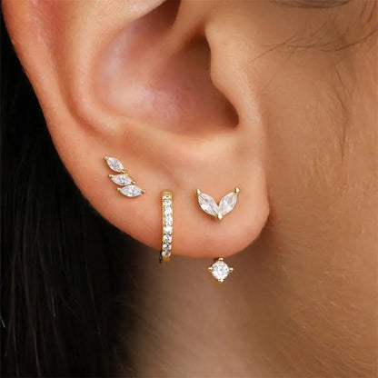Model wearing a stylish three-piece leaf design earring set with zirconia stones, including studs, chain earrings, and hoop.