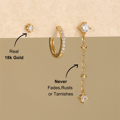 Styled shot of a 3-piece 925 sterling silver jewelry set with zirconia stones, featuring a stud earring, hoop earring, and dangling earring, displayed against a neutral background.