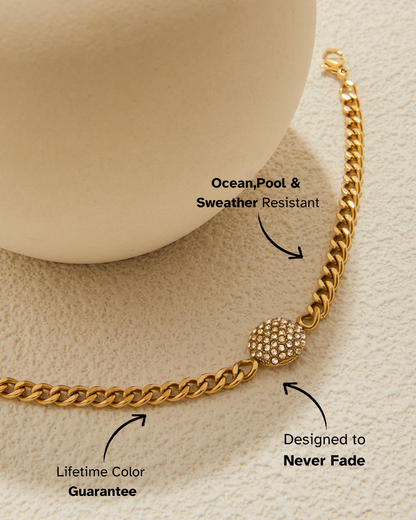 Gold chain bracelet with text highlighting features on a beige background