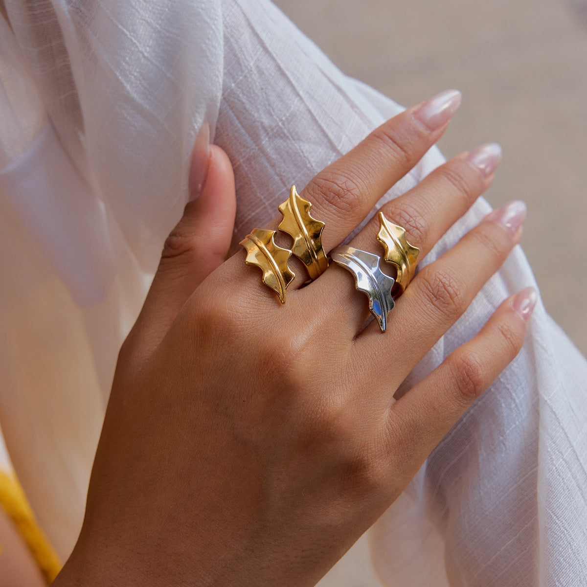 Model wearing two-tone gold and silver leaf ring on hand