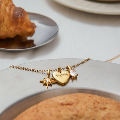 Flat lay of adjustable gold chain necklace with three gold pendants