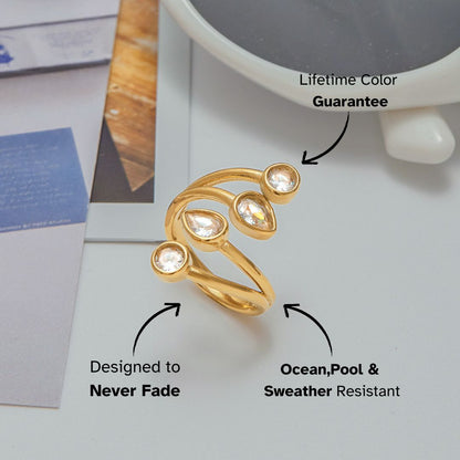 Gold open ring with teardrop and round crystals styled on a magazine