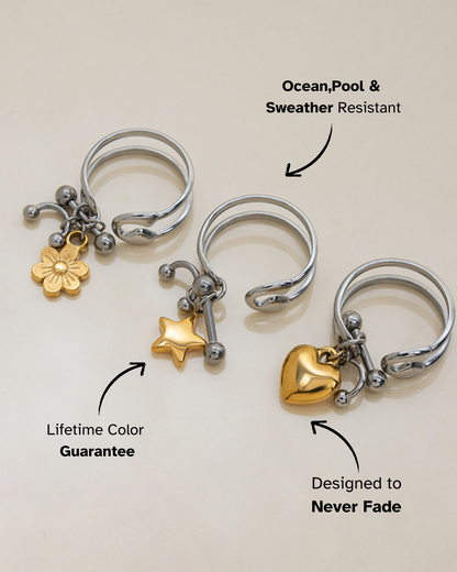 Three silver rings with gold charms on a light background