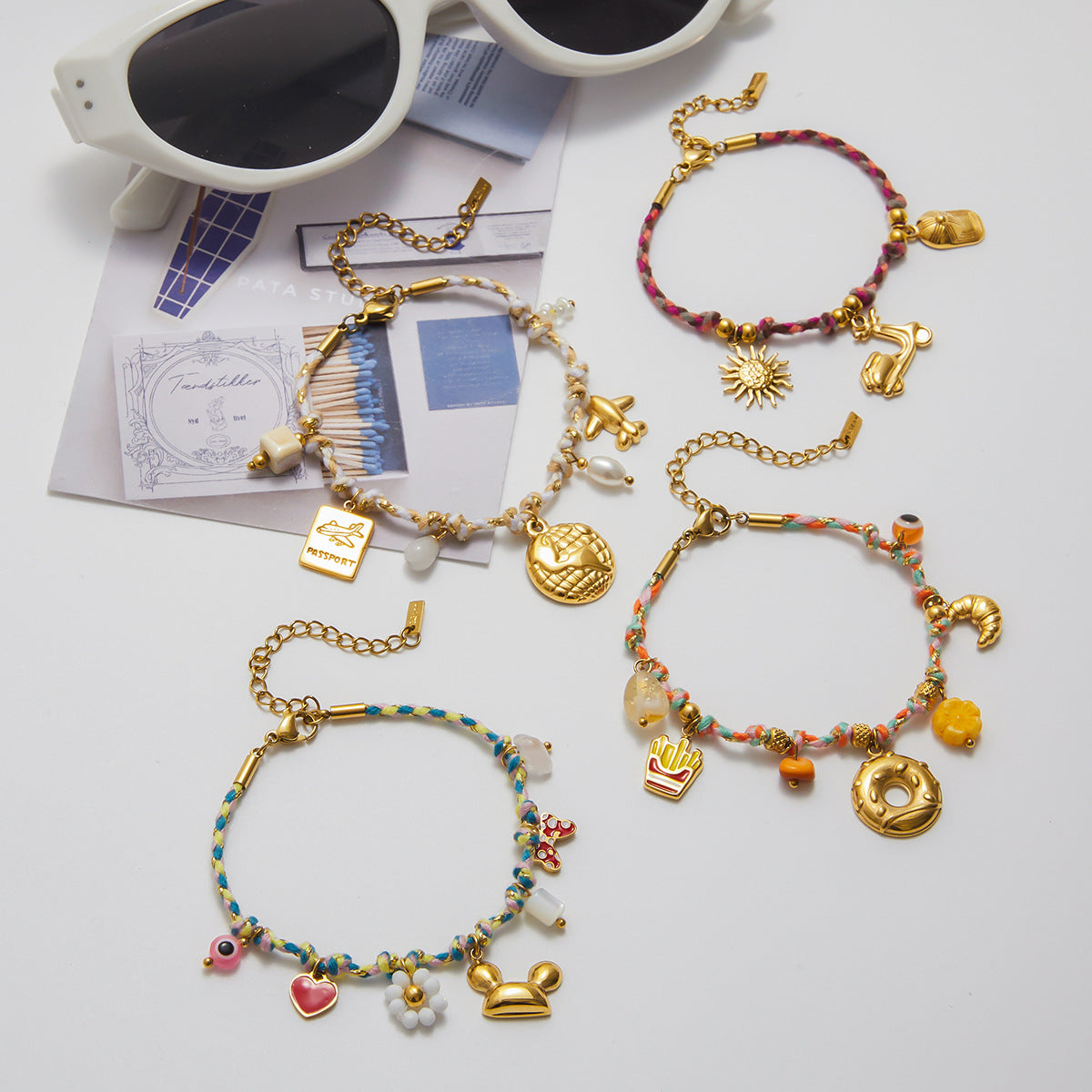 Layered bracelet set featuring gold bangle and boho travel charm bracelet