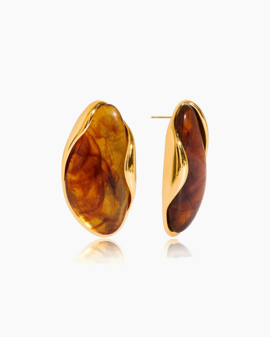 Gold hoop earrings with brown stone centers on a white background