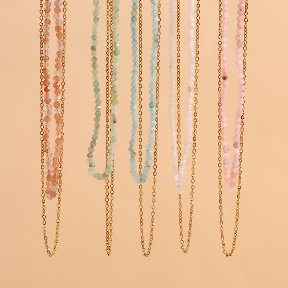 Group of pastel beaded necklaces with double chains, photographed under soft lighting