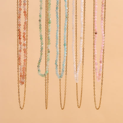 Group of pastel beaded necklaces with double chains, photographed under soft lighting