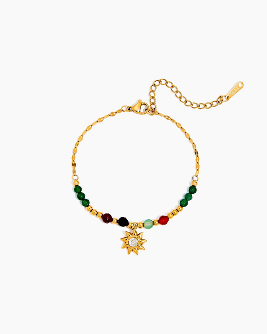 Gold bracelet with colorful beads and a sun charm on a white background