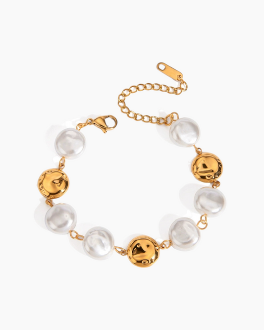 Gold and pearl bracelet on a white background
