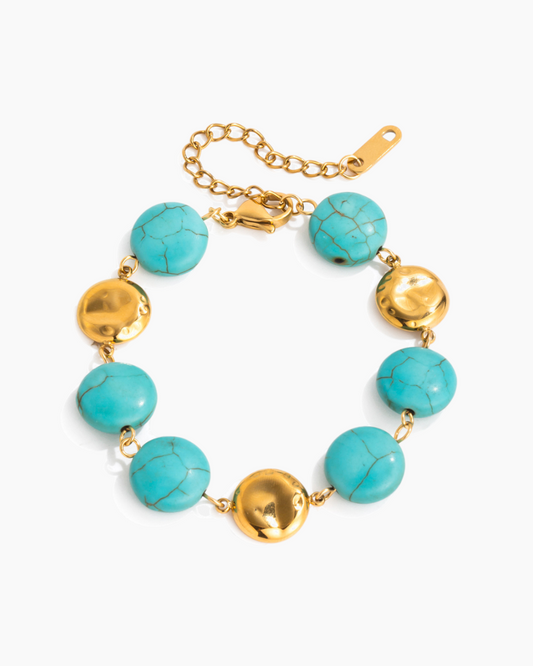 Bracelet with turquoise beads and gold accents on a white background