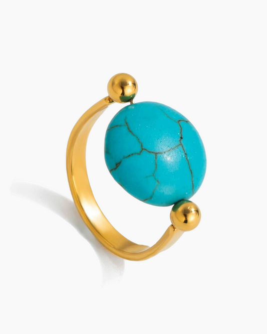 Gold ring with a turquoise bead on a white background