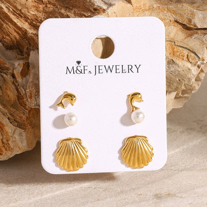 Three-pair gold-tone earring set including shell, pearl, and dolphin studs on branded M&F Jewelry card